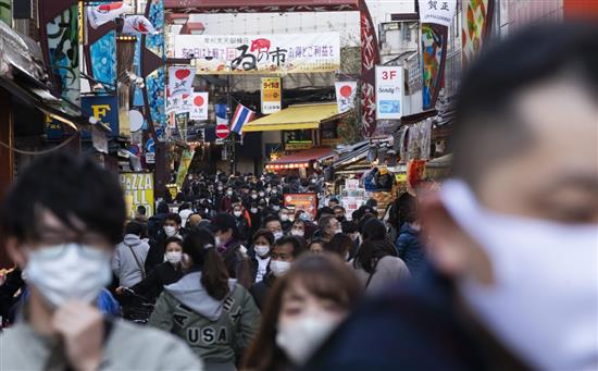 2020年12月31日，人们在日本东京一处商业街逛街。新华社 图